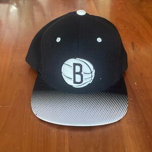 Brooklyn Nets Mitchell & Ness flat-brimmed hat.